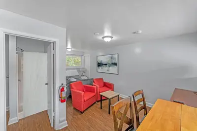 a living room with red chairs and a table at The Main Lineup 3 - All Star Baseball Rentals in Oneonta