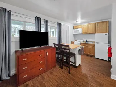 a kitchen with a table and a television on a cabinet at The Main Lineup 3 - All Star Baseball Rentals in Oneonta