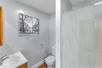a white bathroom with a toilet and a sink at The Main Lineup 3 - All Star Baseball Rentals in Oneonta
