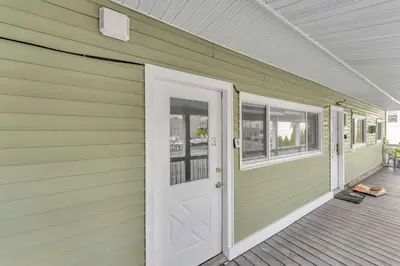 a green house with a white door and windows at The Main Lineup 3 - All Star Baseball Rentals in Oneonta