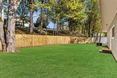 a yard with a fence and a tree at The Main Lineup 3 - All Star Baseball Rentals in Oneonta