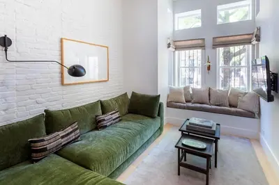 a living room with a green couch and a table at Massive NYC Brownstone wPatio in New York