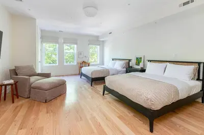 a bedroom with two beds and a couch and a chair at Massive NYC Brownstone wPatio in New York