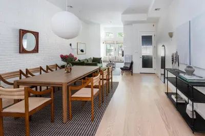 a dining room and living room with a table and chairs at Massive NYC Brownstone wPatio in New York