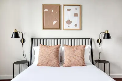 a bedroom with a white bed with two black lamps at Blueground Murray Hill balcony nr East River NYC-720 in New York