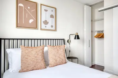 a bedroom with a white bed with two pillows at Blueground Murray Hill balcony nr East River NYC-720 in New York