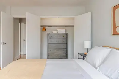 a bedroom with a white bed and a dresser at Blueground Lenox Hill view nr Central Park NYC-2019 in New York