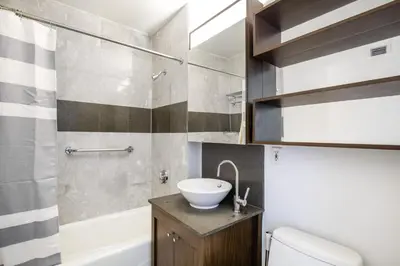 a bathroom with a sink and a toilet and a tub at Blueground Chelsea rooftop nr Highline NYC-369 in New York