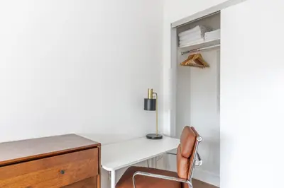 a desk with a chair next to a closet at Blueground Clinton Hill rooftop nr Fort Greene Park NYC-1979 in Brooklyn