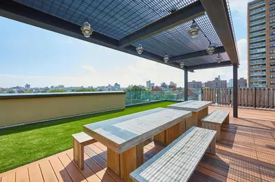 a patio with tables and benches on a roof at Blueground Clinton Hill rooftop nr Fort Greene Park NYC-1979 in Brooklyn