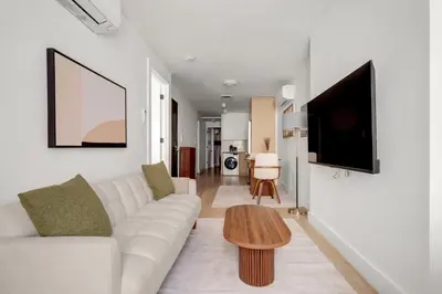 a living room with a white couch and a wooden table at Blueground Midtown East view nr UN Plaza NYC-2040 in New York
