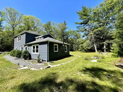 a small house in the middle of a yard at Cozy Cottage in Glen Spey in Glen Spey