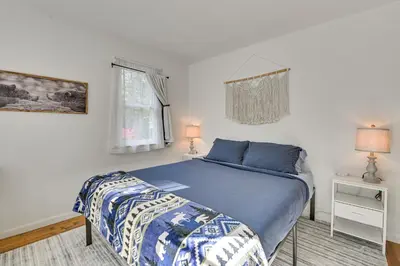 a bedroom with a blue bed and a window at Ice Fish, Snowshoe and Ski Group Getaway in Summit in Summit