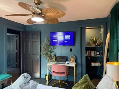 a room with a ceiling fan and a desk with a laptop at Chic Hudson Escape Pet Friendly Hot Tub in Hudson