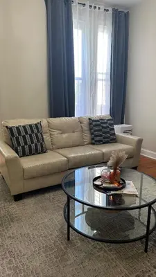 a living room with a couch and a glass table at Modern Comfort 1BR in Jersey City in Jersey City