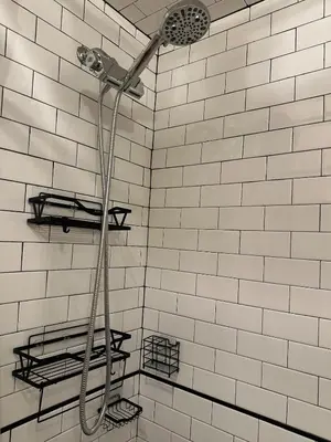 a shower in a bathroom with white tiles at Modern Comfort 1BR in Jersey City in Jersey City