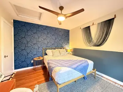 a bedroom with a bed and a blue wall at Vibing Hudson Retreat Pet-Friendly w Hot Tub in Hudson