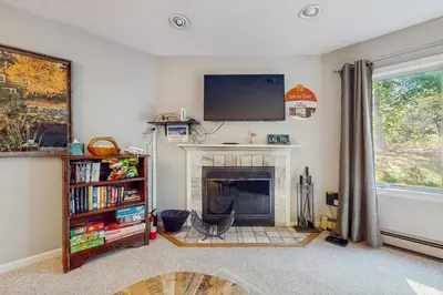 a living room with a fireplace and a flat screen tv at Deer Creek 8A in Dover