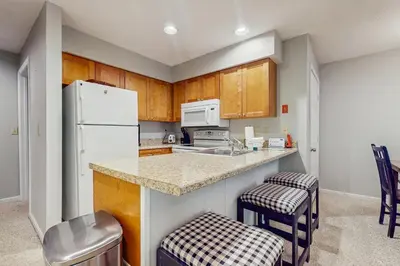 a kitchen with wooden cabinets and a white refrigerator at Deer Creek 8A in Dover