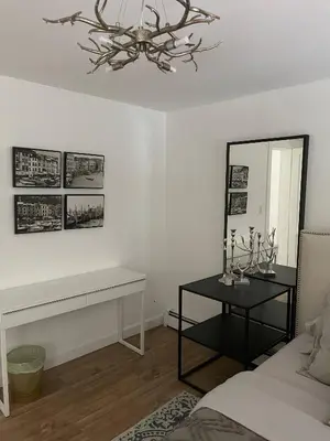 a living room with a table and a mirror at 5 Min walk to Stony Brook University in Stony Brook
