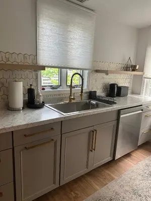 a kitchen with white cabinets and a sink and a window at 5 Min walk to Stony Brook University in Stony Brook