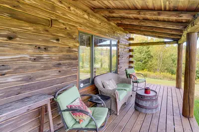 a porch of a cabin with chairs and a table at Cozy Log Cabin Near Mt Snow Views, Modern Comfort in Wilmington
