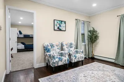 a living room with a chair and a bedroom at Family Oasis Pool Firepit Creek Near Delaware in Sparrow Bush