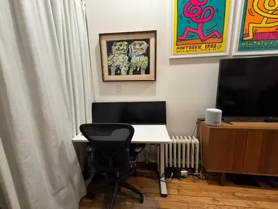 a room with a desk with a computer and a television at West Village Apartment Rent 30 days or more in New York