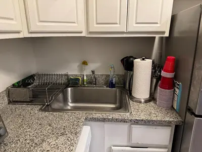 a kitchen counter with a sink and white cabinets at West Village Apartment Rent 30 days or more in New York