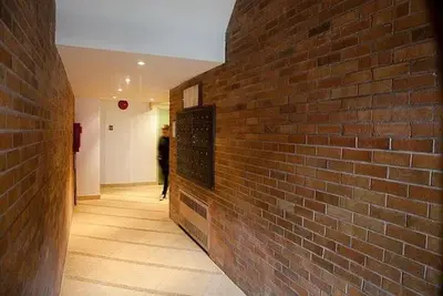 a brick wall with a person walking down a hallway at West Village Apartment Rent 30 days or more in New York