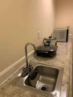 a kitchen counter with a sink with a pot at Cozy1B1B W Private Entrance in Jericho