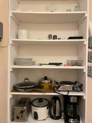 a kitchen shelf with pots and pans and dishes at Cozy1B1B W Private Entrance in Jericho