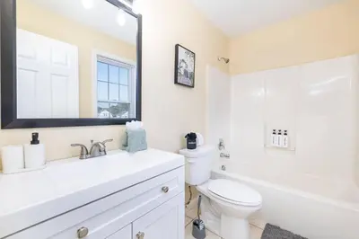 a white bathroom with a sink and a toilet at Bright & Cozy Stay in the Heart of Hartford in Hartford
