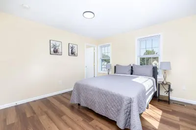 a white bedroom with a bed and two windows at Bright & Cozy Stay in the Heart of Hartford in Hartford