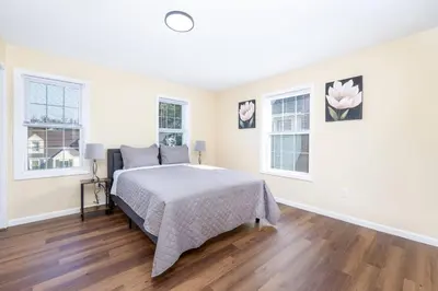 a bedroom with a bed and two windows at Bright & Cozy Stay in the Heart of Hartford in Hartford