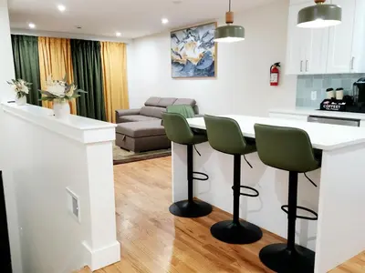 a kitchen and living room with a table and chairs at Luxury 3BR Retreat Near NYC in Newark