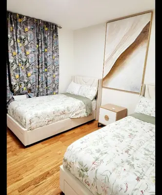 a bedroom with two beds and a curtain at Luxury 3BR Retreat Near NYC in Newark