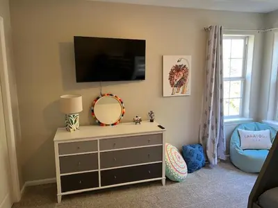 a room with a dresser with a mirror and a tv at Saratoga Getaway in Saratoga Springs