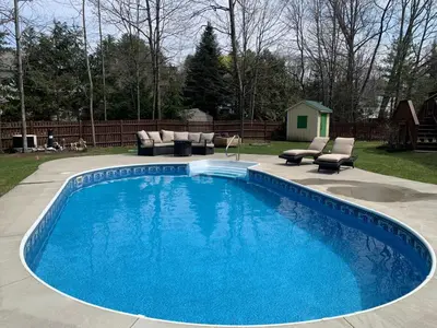 a large blue pool with lounge chairs at Saratoga Getaway in Saratoga Springs