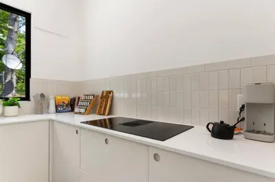 a white kitchen with a sink and a microwave at Modern Family Retreat in the Catskills Wilderness in Round Top