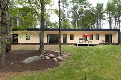 a house in the middle of a yard with trees at Modern Family Retreat in the Catskills Wilderness in Round Top