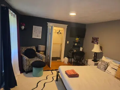 a bedroom with a bed and a couch and a table at Hidden and comfortable home away from home in Manchester