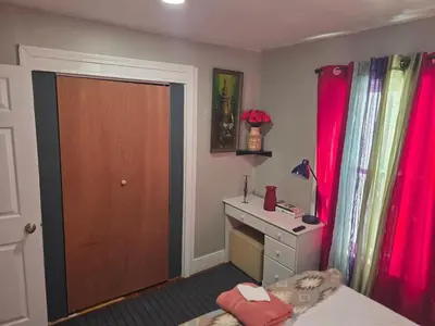 a bedroom with a bed and a desk and a door at Hidden and comfortable home away from home in Manchester