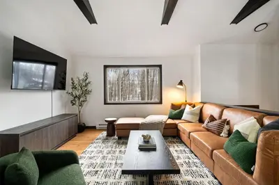 a living room with a couch and a table at Cozy Poconos Retreat - pool table, hot tub, fire pit in Tobyhanna