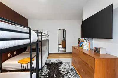 a bedroom with two bunk beds and a flat screen tv at Cozy Poconos Retreat - pool table, hot tub, fire pit in Tobyhanna