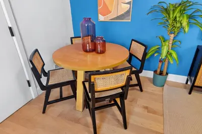 a dining room table with chairs and a blue wall at Spacious 3Bedroom with AC near McCarren Park Brooklyn Stay in Brooklyn
