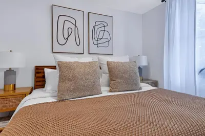 a bedroom with a large bed with two pictures on the wall at Spacious 3Bedroom with AC near McCarren Park Brooklyn Stay in Brooklyn