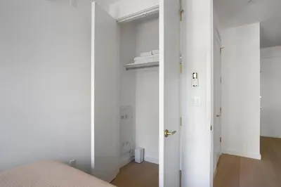 a bedroom with white walls and a white door at Blueground Greenpoint view nr McGolrick Park NYC-2071 in Brooklyn
