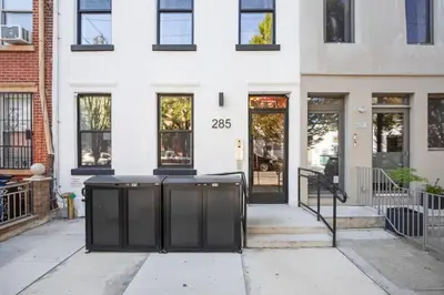 a front door of a white building with black gates at Blueground Greenpoint view nr McGolrick Park NYC-2071 in Brooklyn