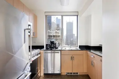 a kitchen with a sink and a window at Blueground Hells Kitchen fitness center nr Hudson River Park NYC-2086 in New York